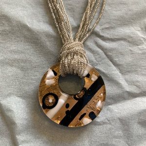Silver beaded necklace with gold/white/black accent medallion